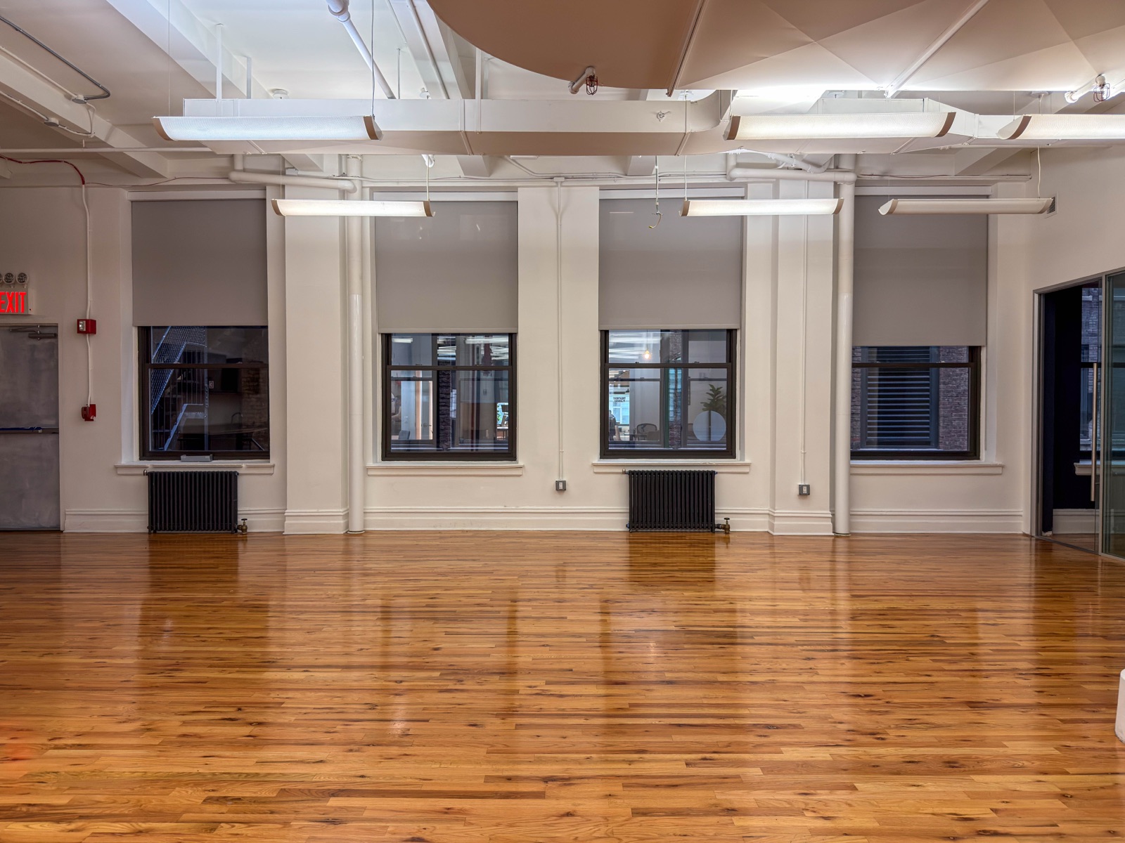 The back half of the open floor, windows and radiators